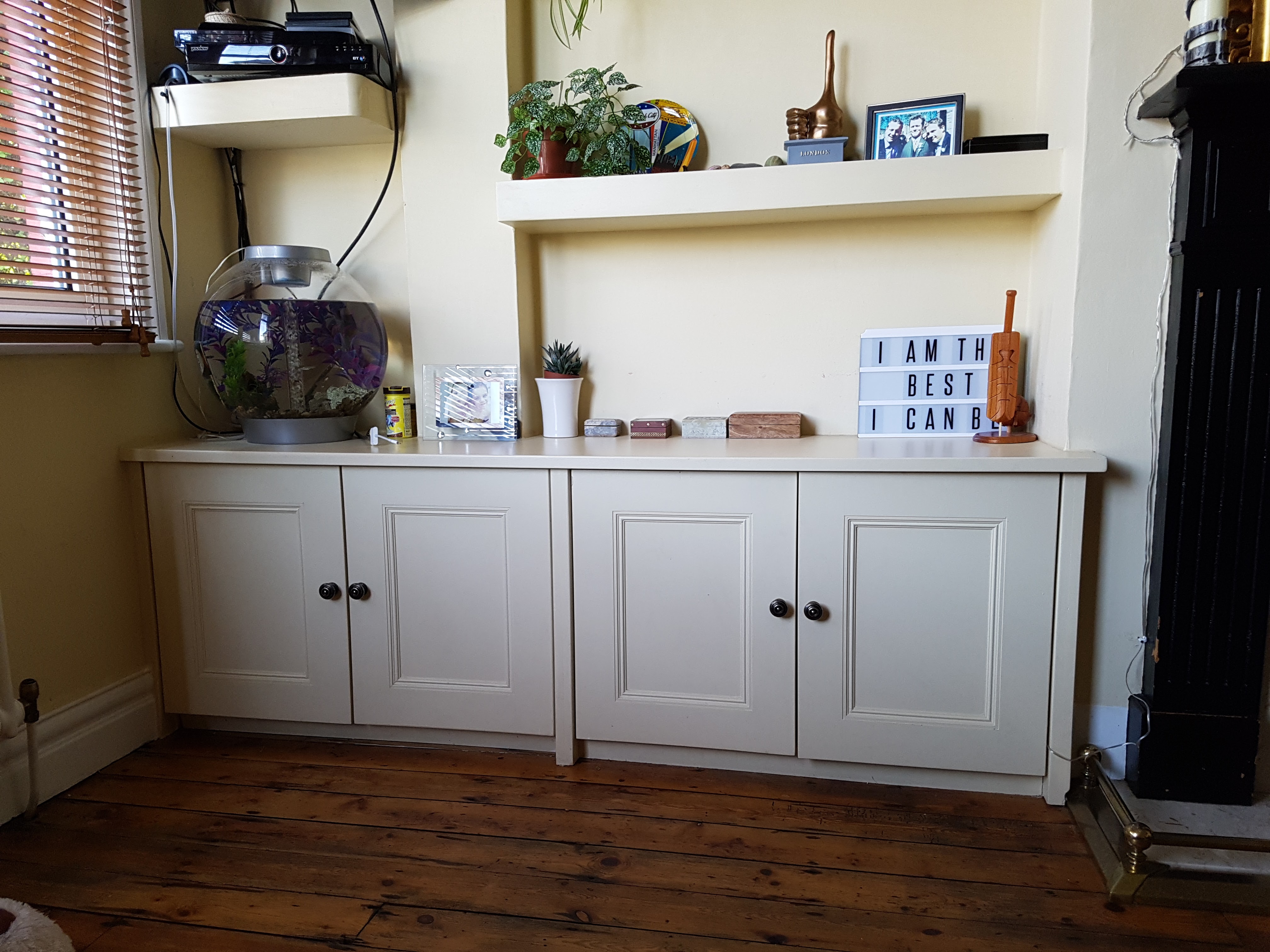 Traditional Slaked Lime alcove unit with cupboards and shelving in a living room.