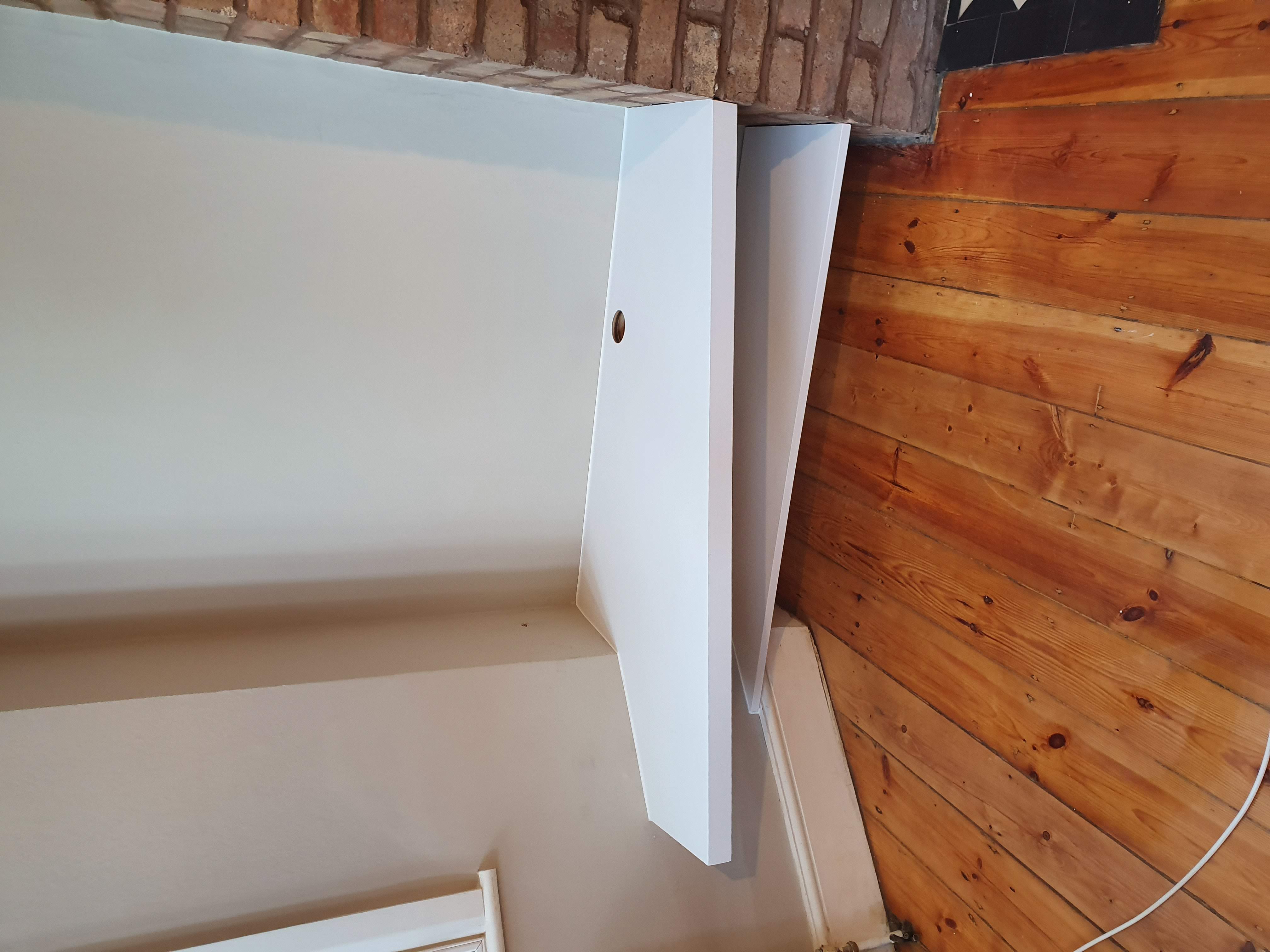 Minimalist white alcove floating shelving unit in a living room, perfect for media or display.