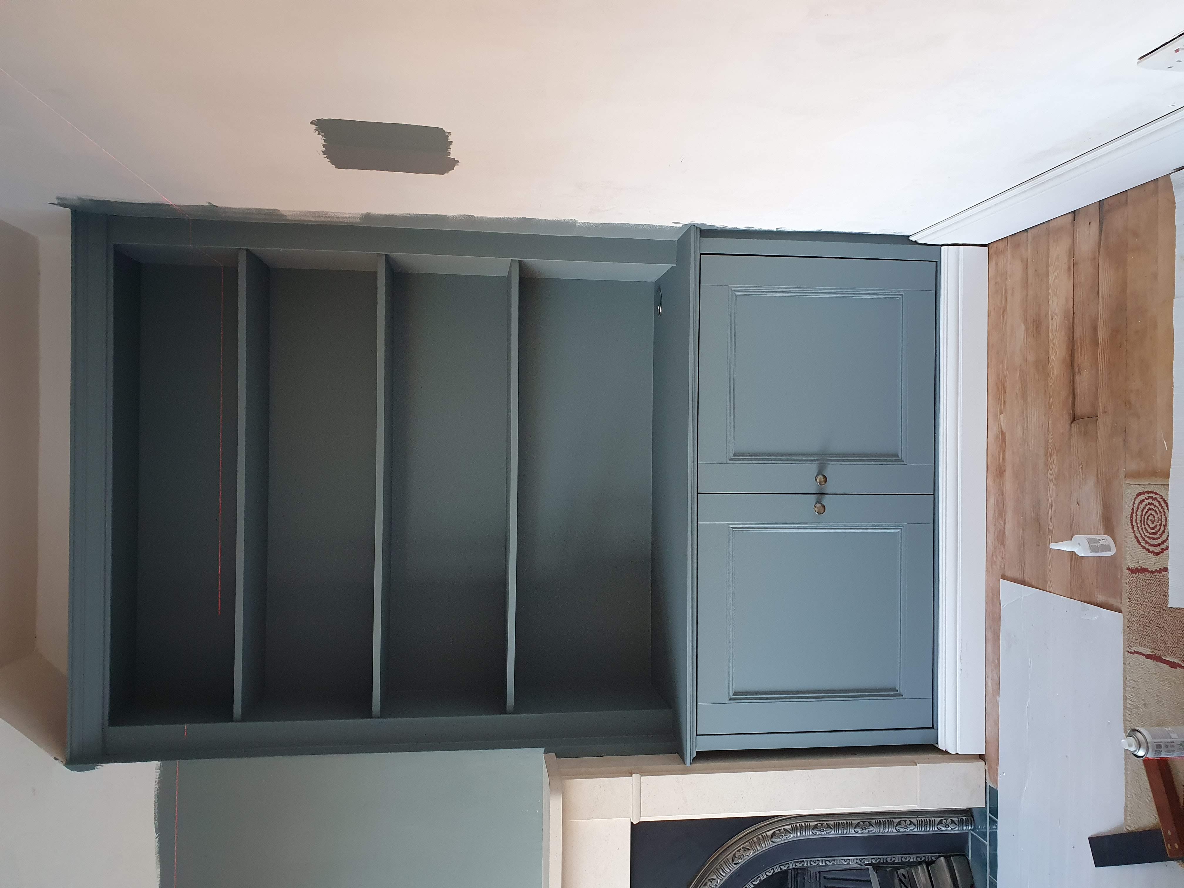 Traditional fitted bookcase in Farrow & Ball Railings black, built around a fireplace in a living room.