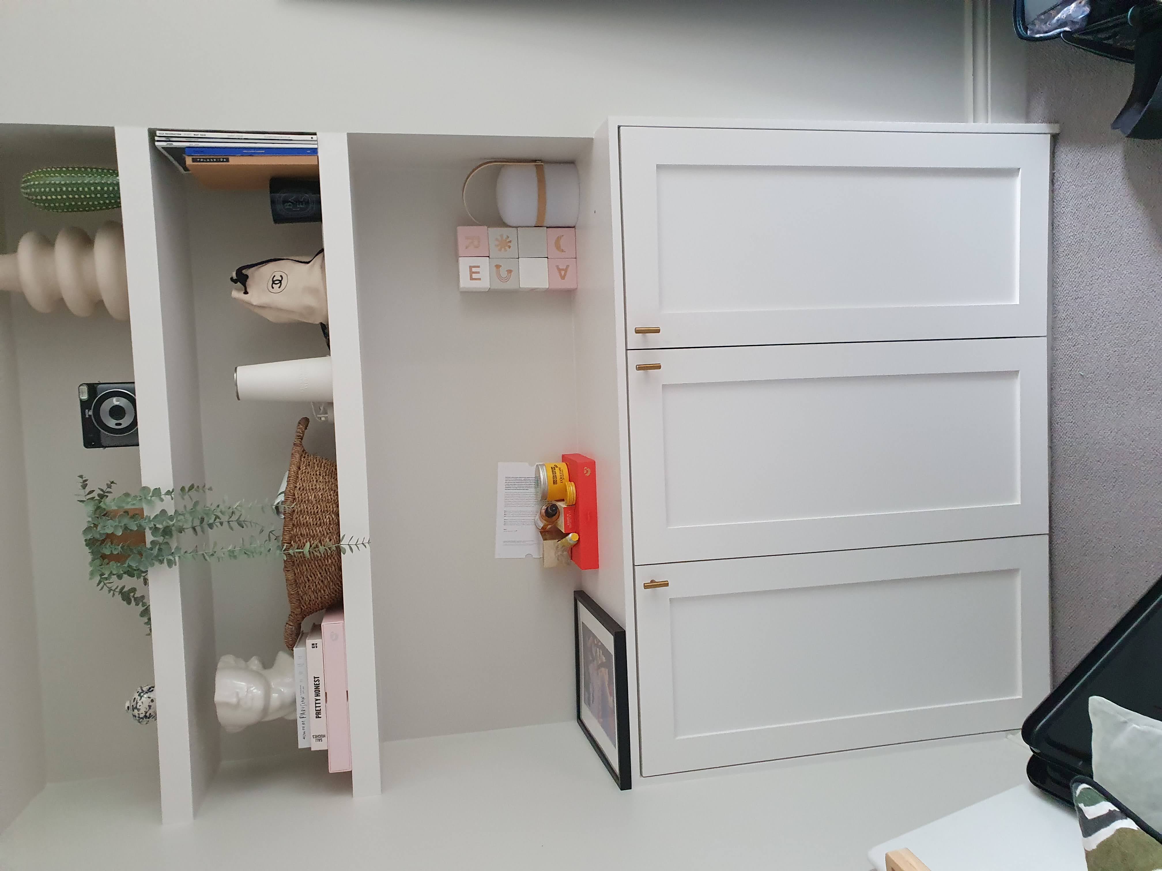 Pair of bespoke Shaker style alcove units in white, flanking a fireplace in a living room.