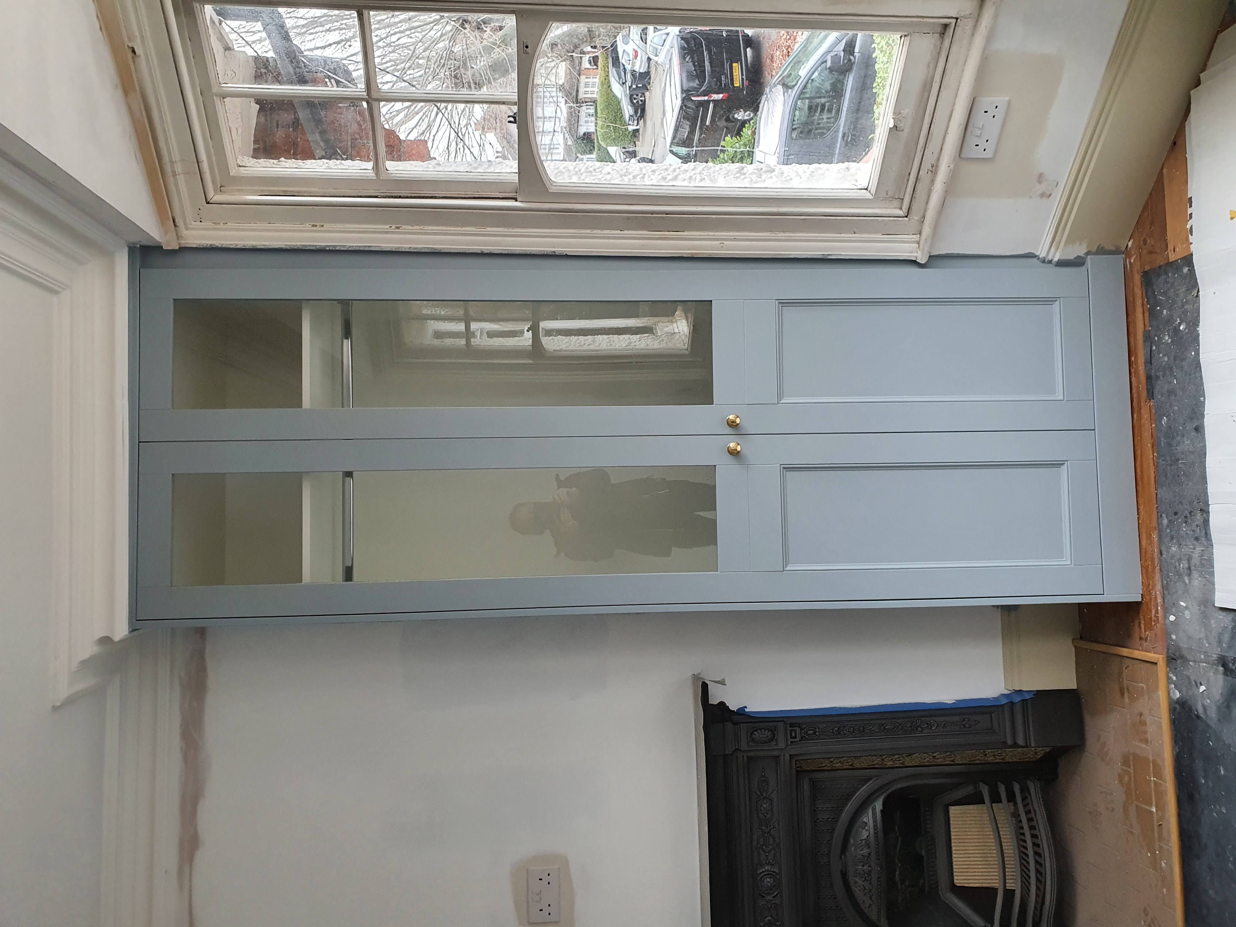 Fitted Shaker style alcove unit in Shaded White with brass hardware and floating shelves.