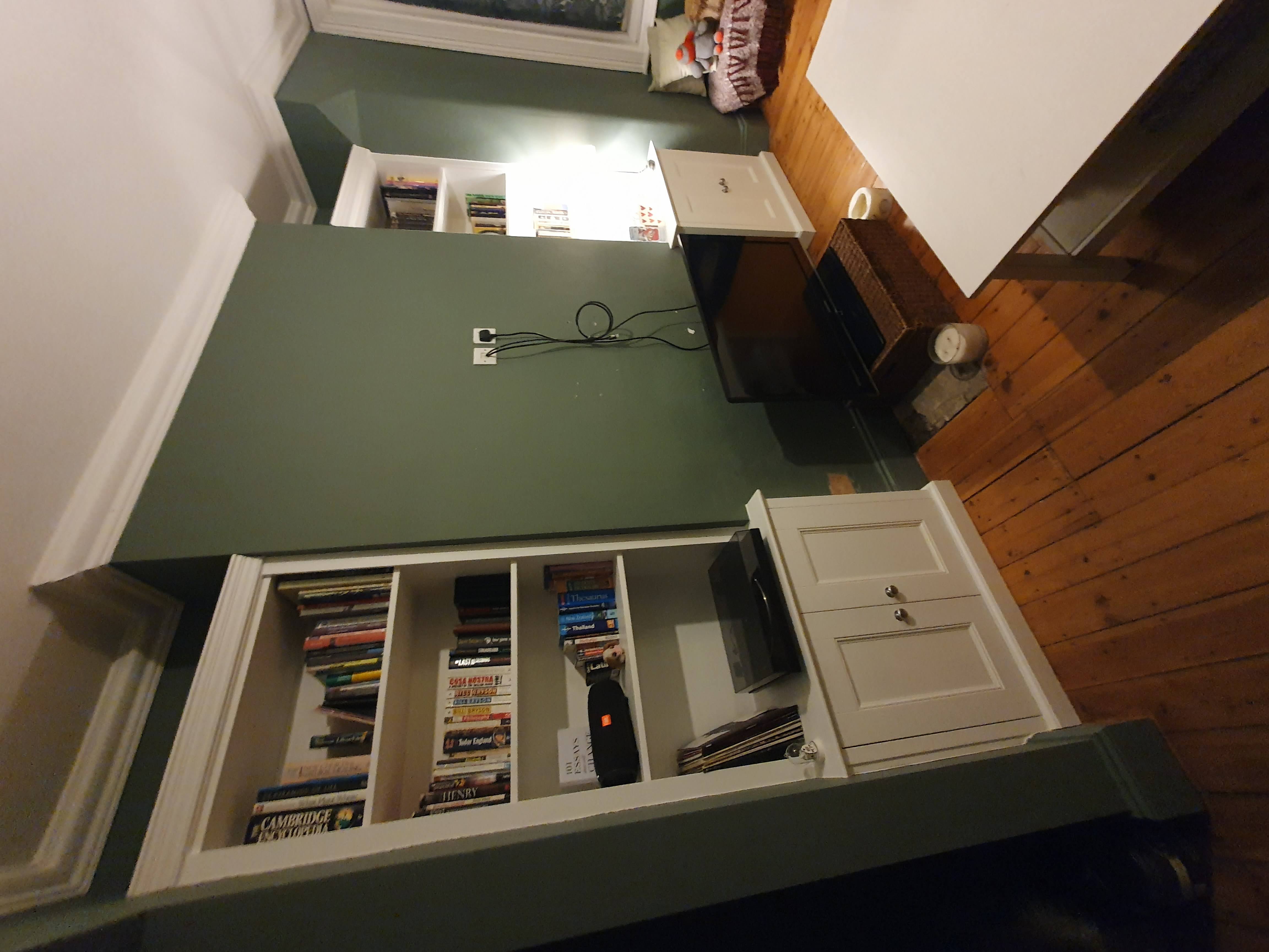 Traditional white fitted bookcase with shaker doors in a living room.