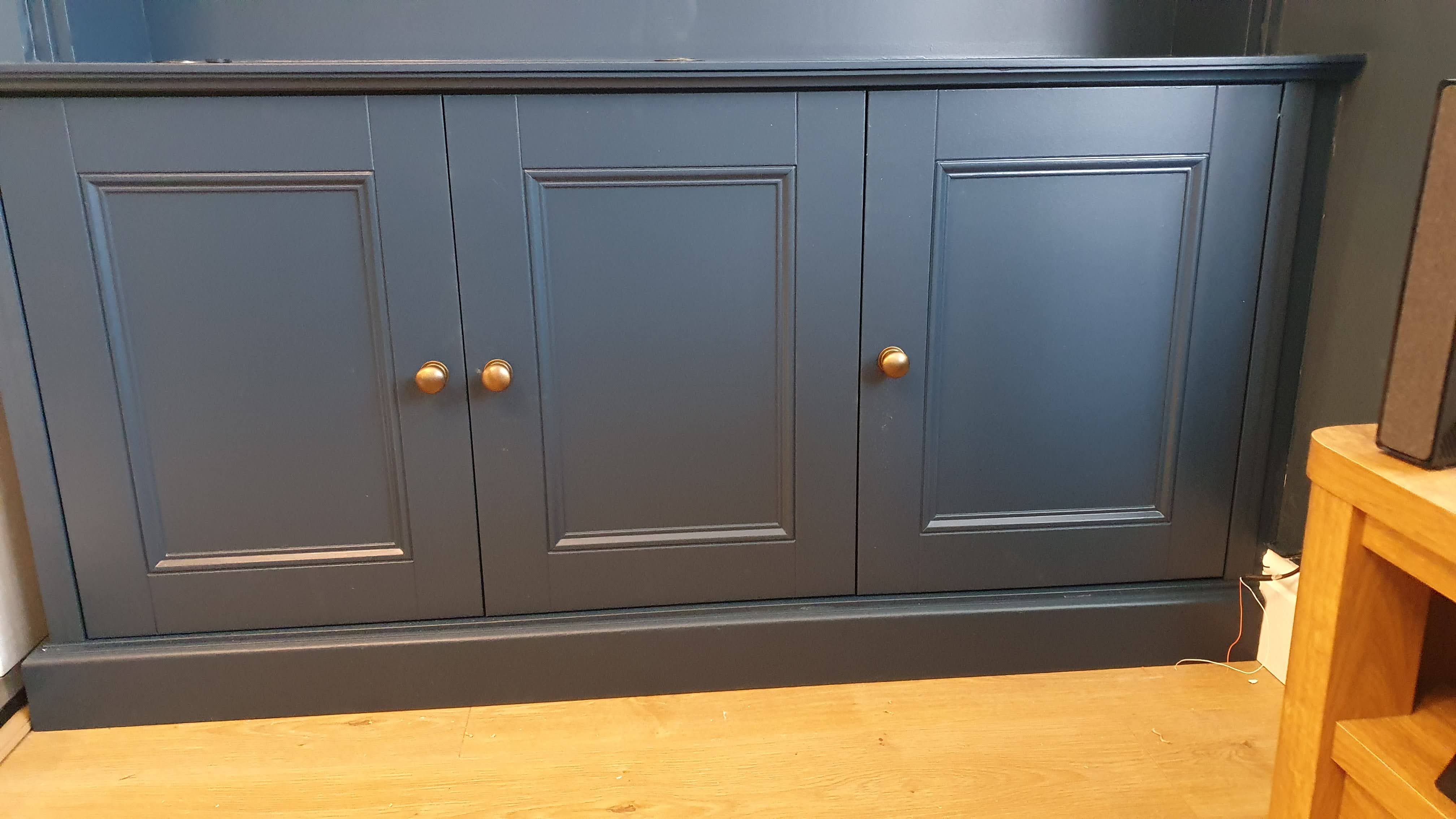 Traditional Hague Blue alcove unit in a living room with brass knobs and open shelving.