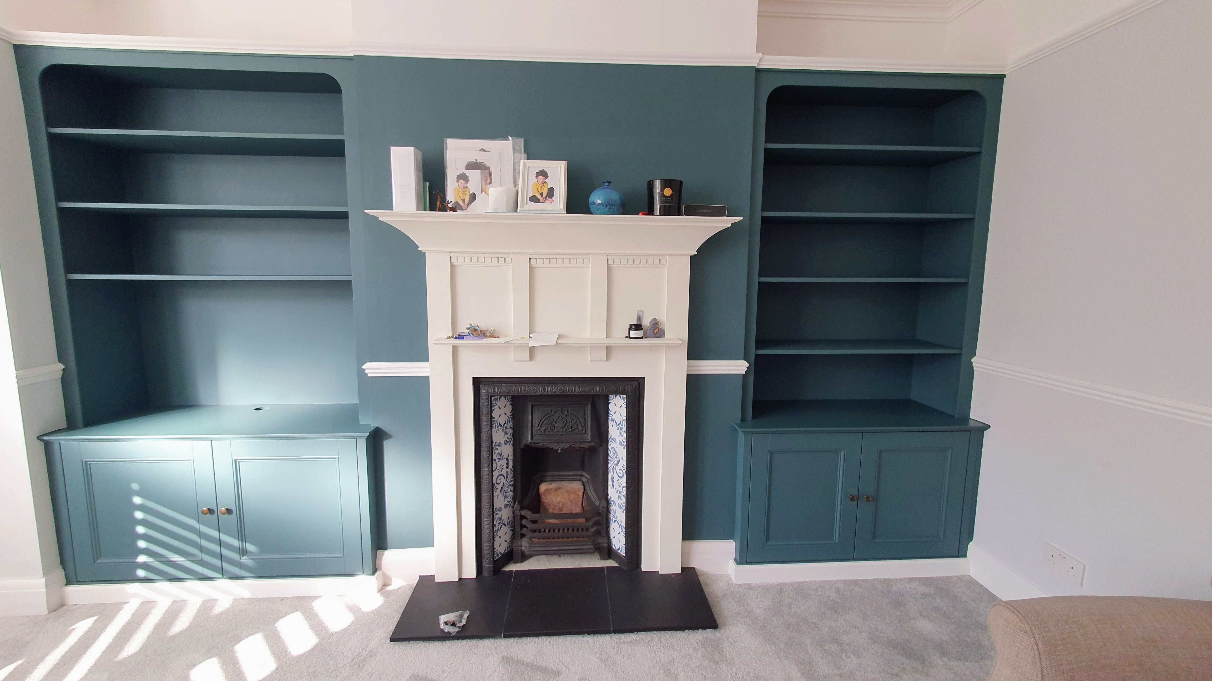Traditional Hague Blue alcove unit in a living room with an integrated media cabinet and open shelving.