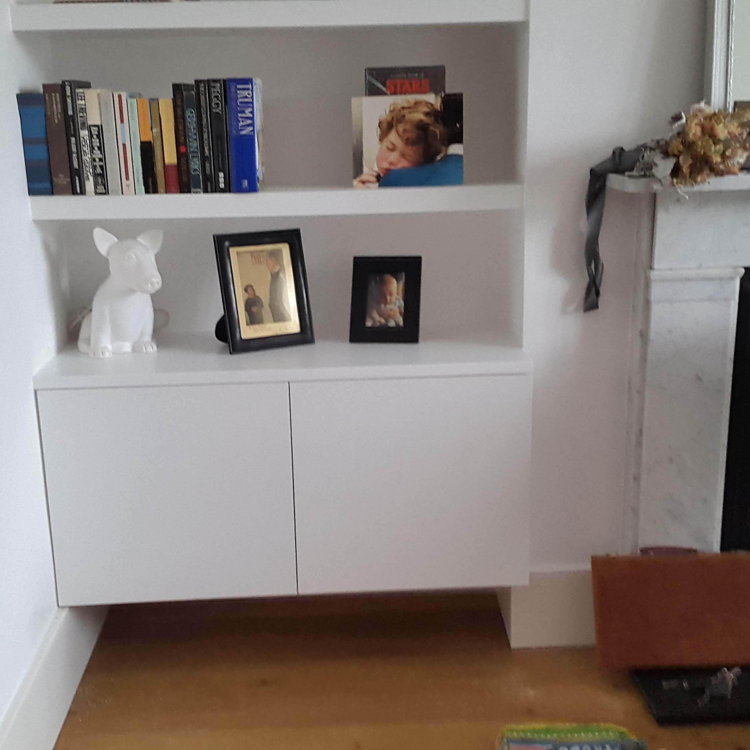 Fitted Shaker style TV unit in Skimming Stone (light grey) with brass knobs in a living room.