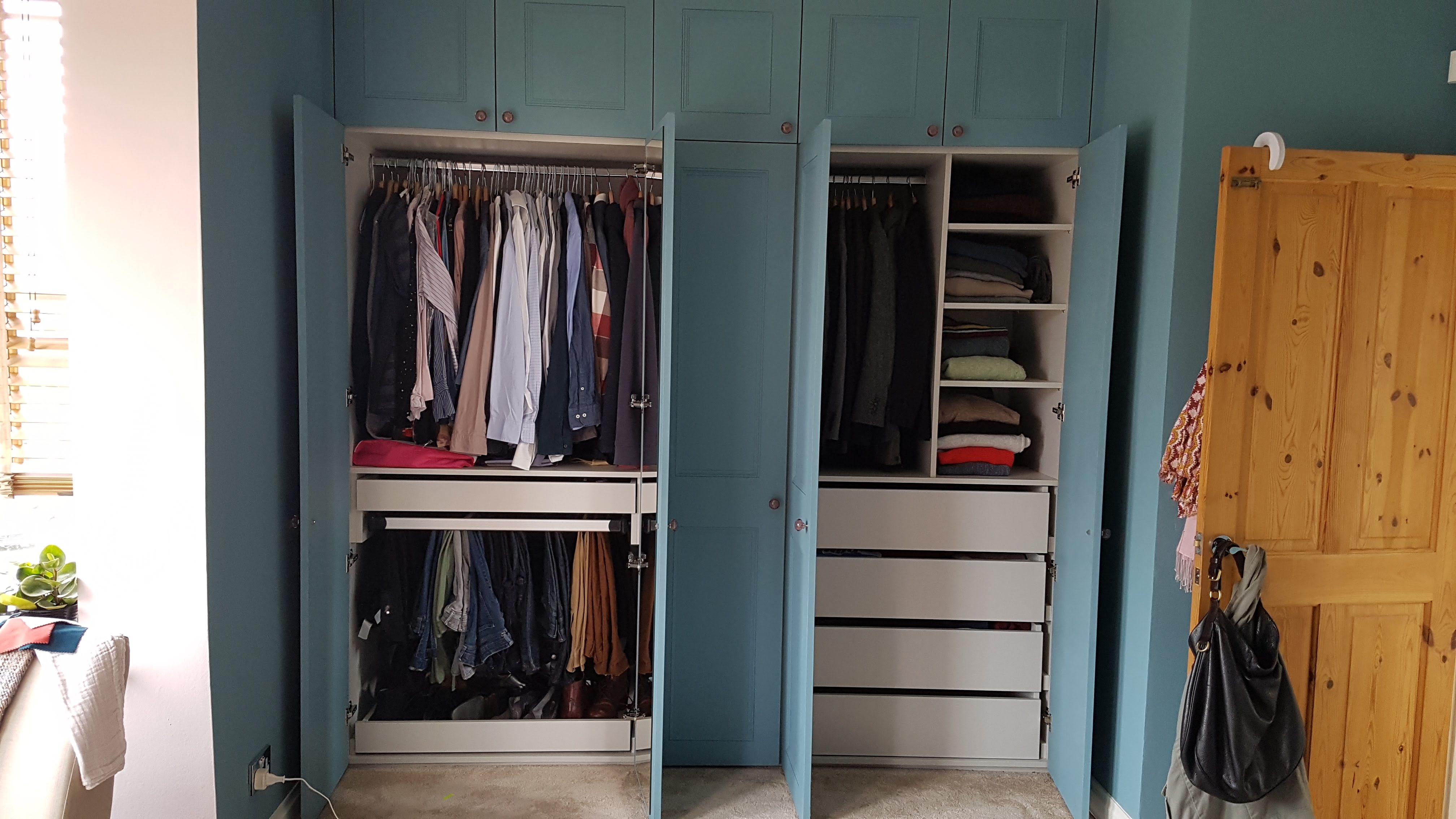 Shaker style fitted wardrobe in Hague Blue with brass knobs, offering ample storage for a bedroom.