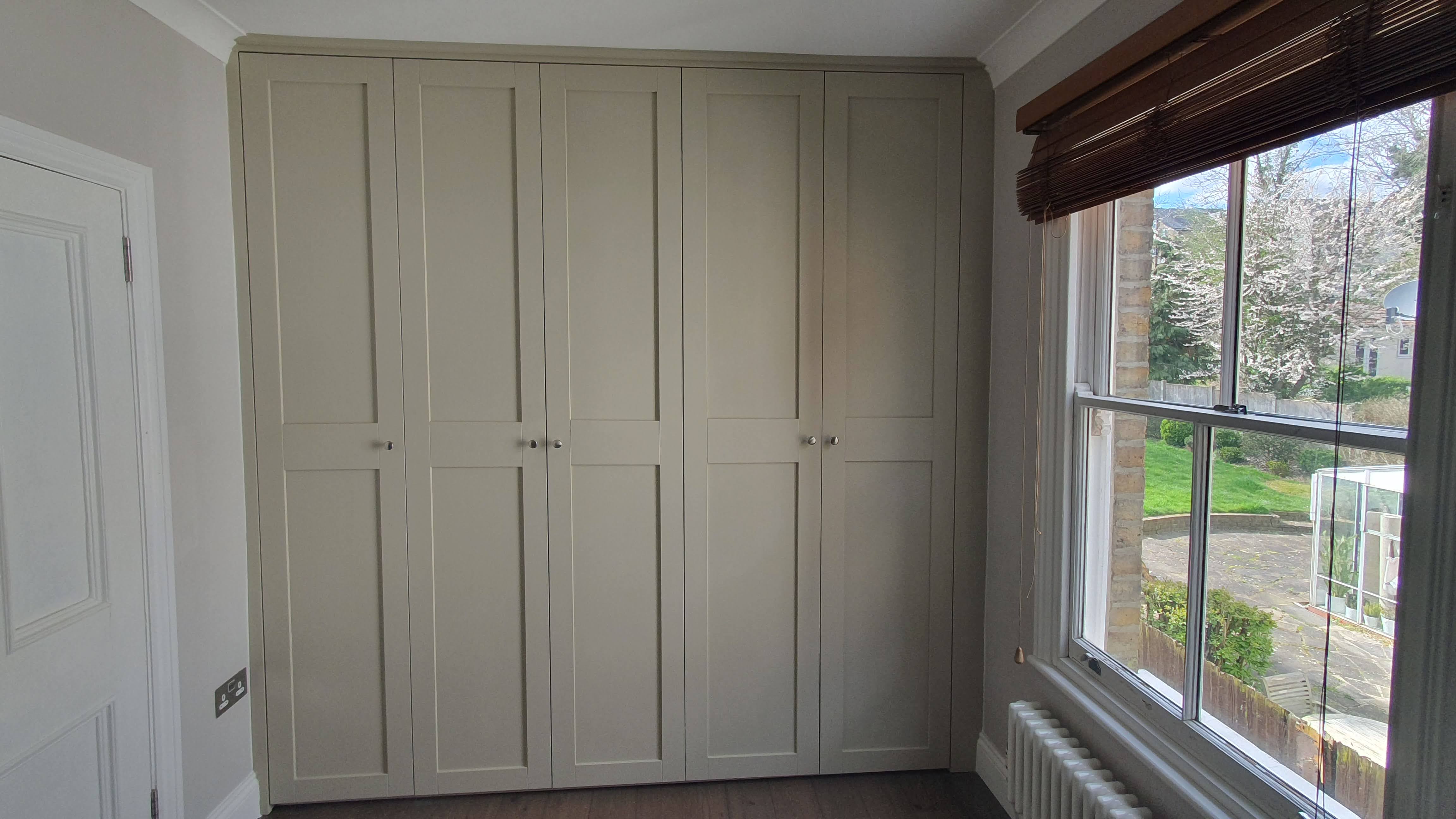 Shaker style fitted wardrobe in Skimming Stone a Farrow and Ball neutral paint color, perfect for bedroom storage.