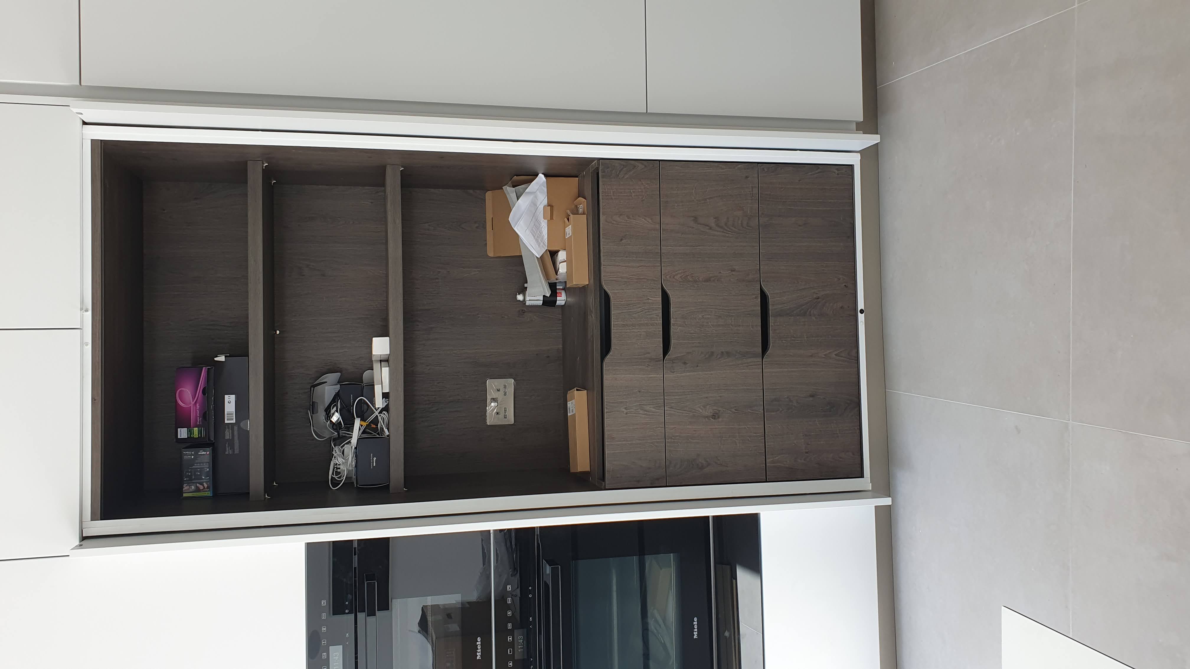 Modern built-in storage cabinet in walnut finish for a kitchen, featuring shelves and integrated drawers.