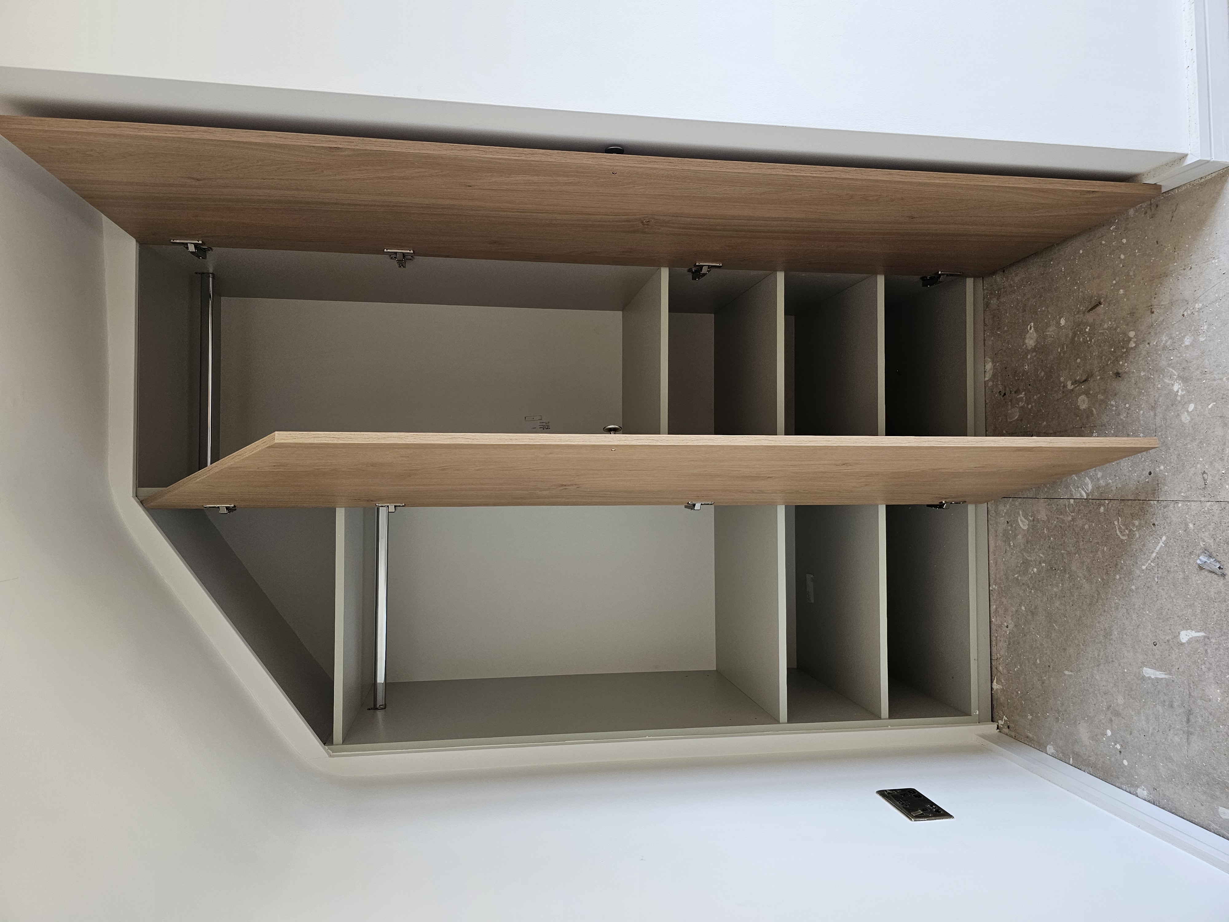 Modern fitted wardrobe with natural oak doors and a sloped ceiling design, providing efficient storage in a bedroom.