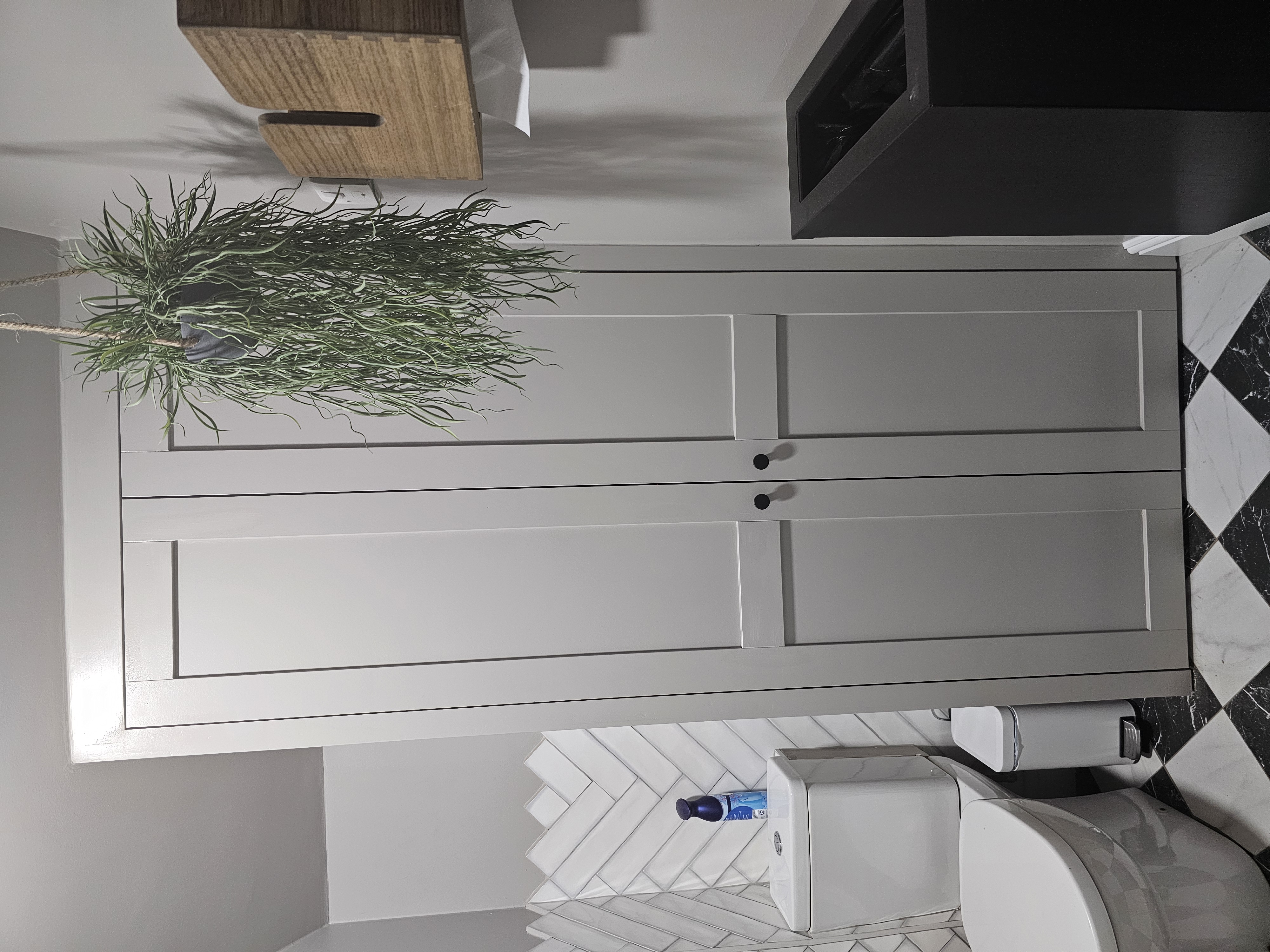Fitted Shaker style wardrobe in light gray paint, perfectly integrated into a modern bathroom interior.
