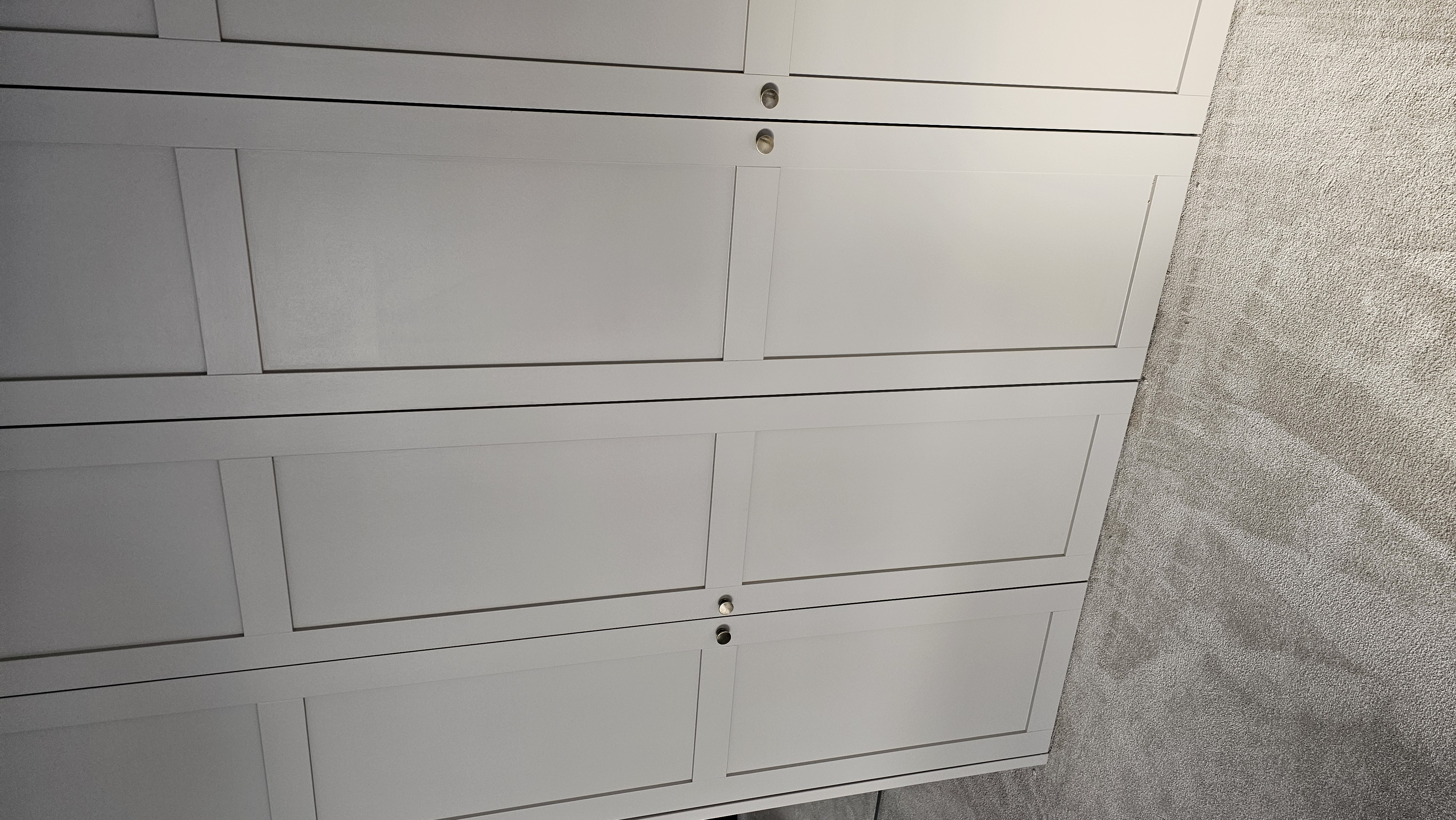 Light grey shaker style fitted wardrobe in a modern bedroom