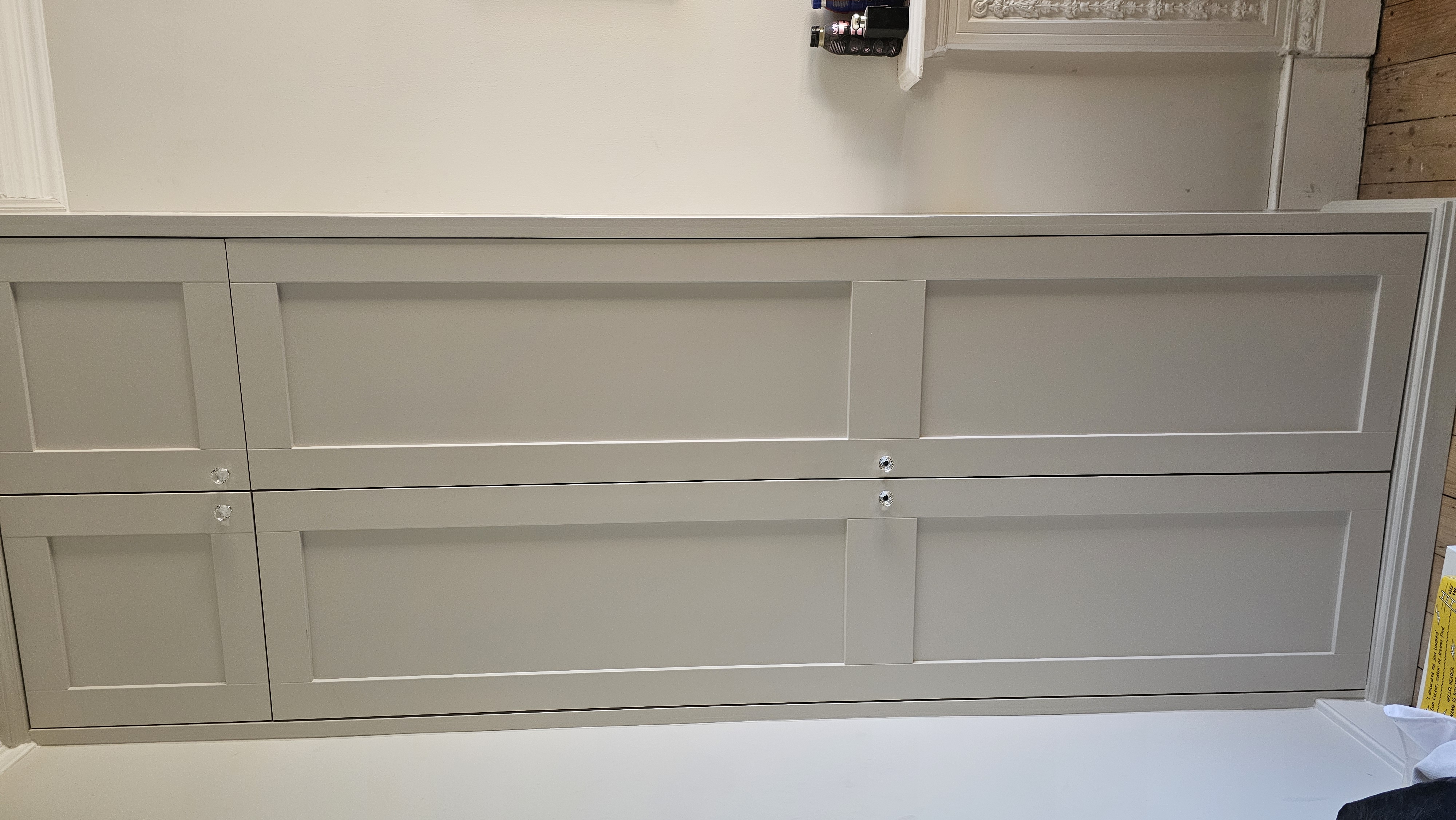 Fitted Shaker wardrobe in Farrow and Ball Elephant's Breath with crystal knobs for bedroom storage.