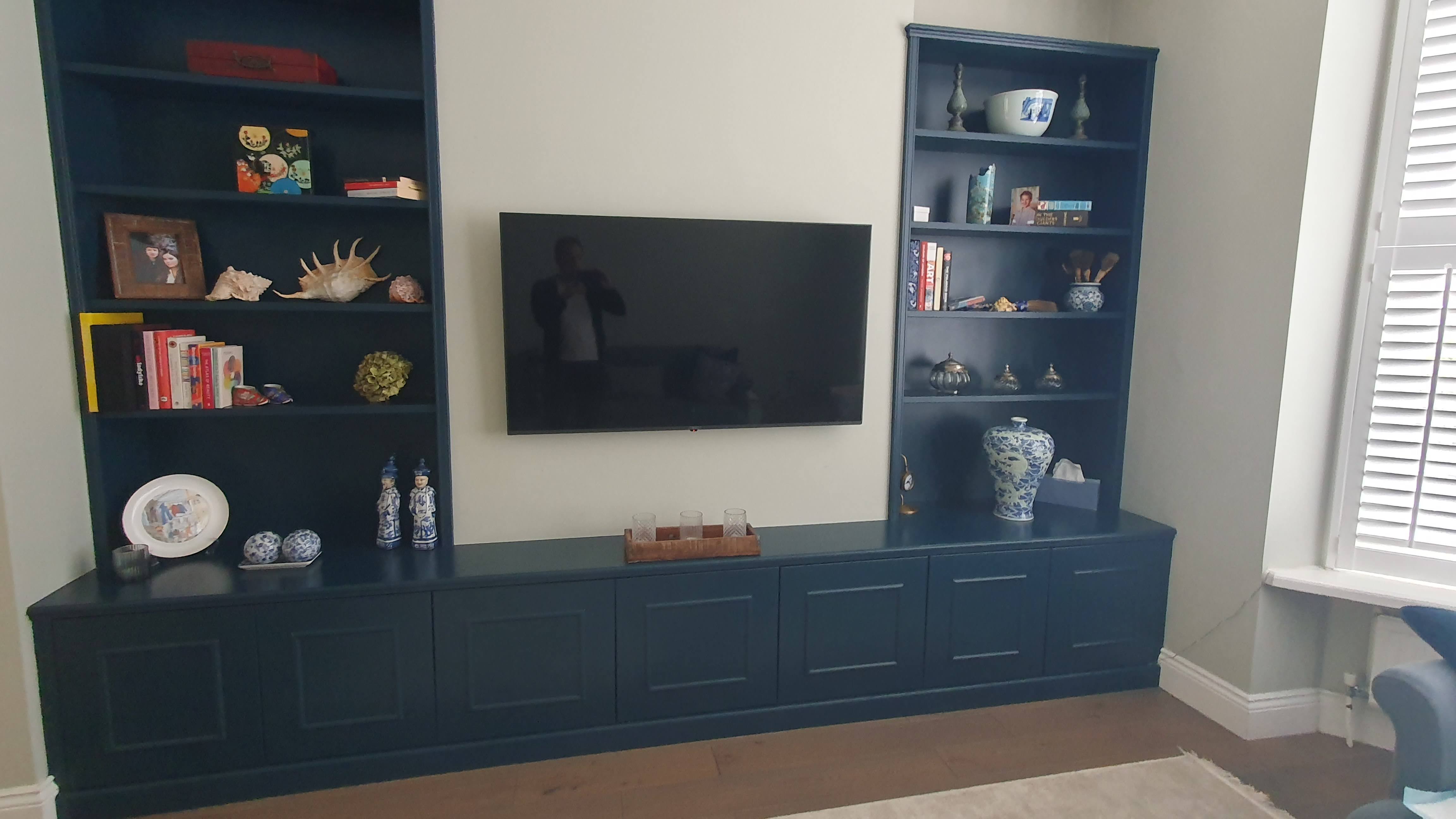 Traditional Hague Blue alcove unit in a living room, featuring built-in bookshelves and a media console with shaker style doors.