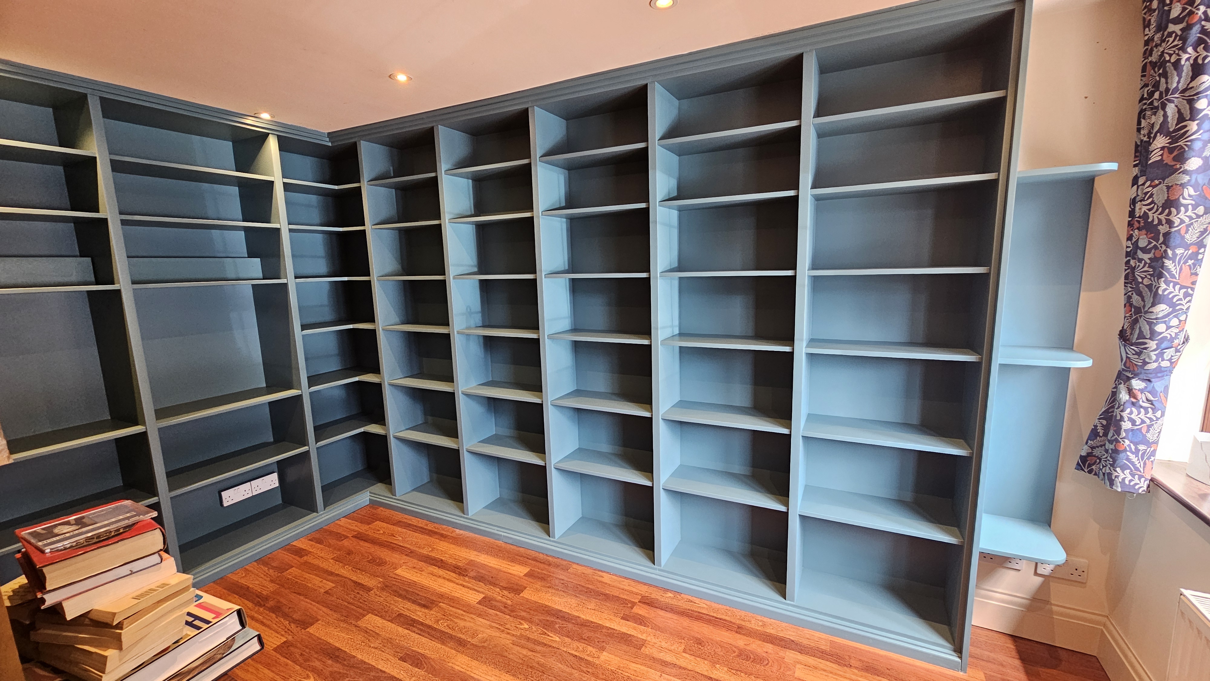 Fitted Hague Blue Traditional Bookcase with integrated lighting in a living room.