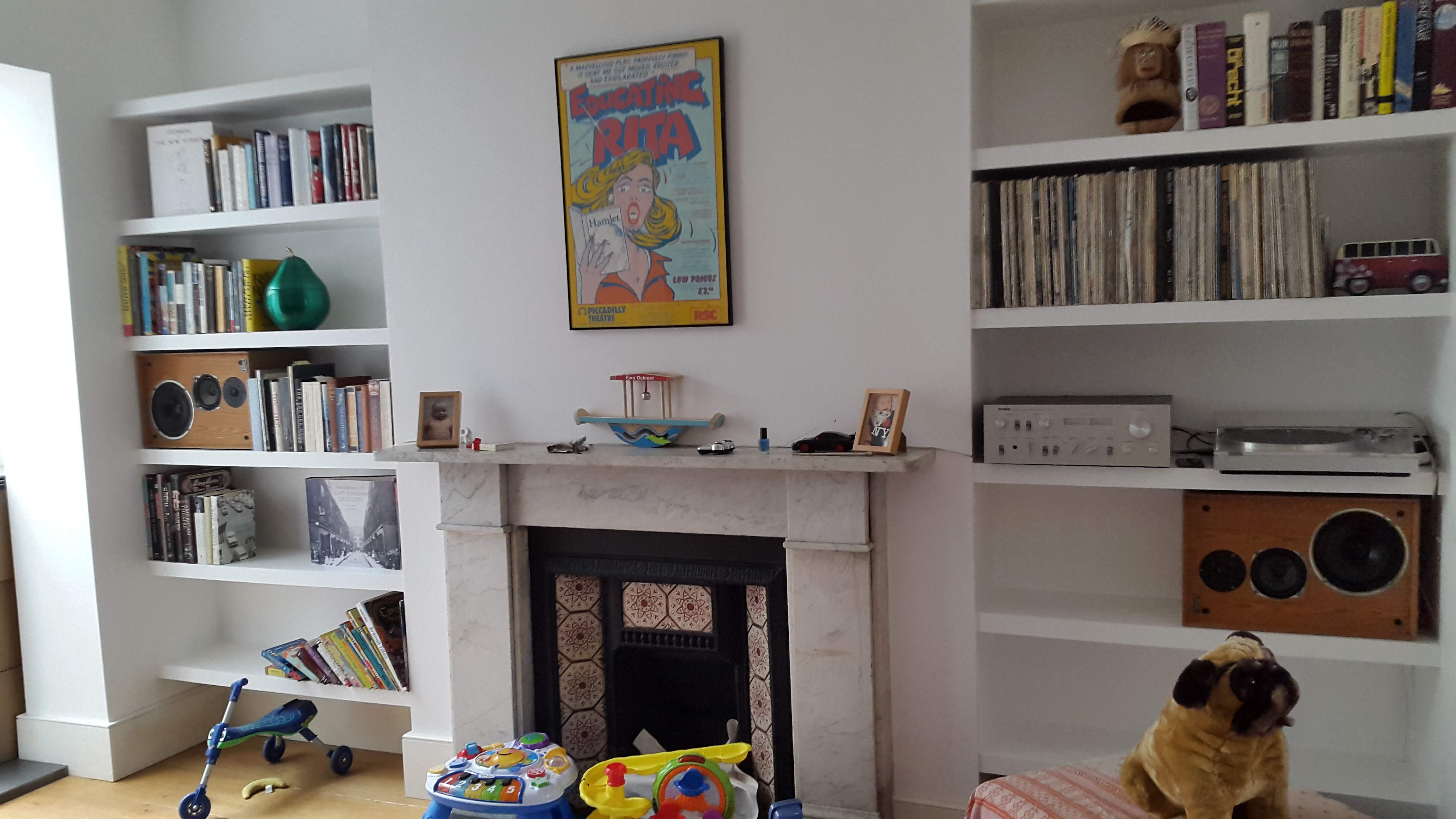 Traditional white alcove units flanking a fireplace in a living room, providing custom built-in shelving.